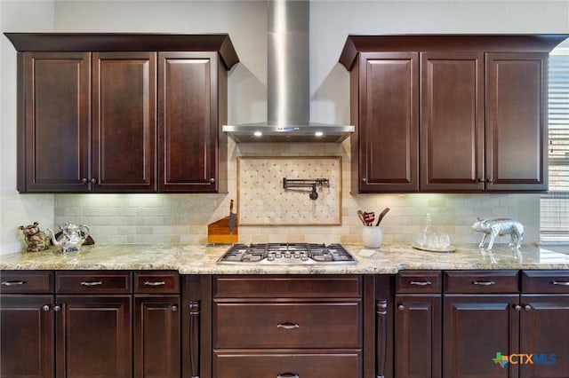 1919 Los Santos Dr, San Marcos, TX 78666 - kitchen with wall chimney range hood, dark brown cabinetry, stainless steel gas cooktop, and backsplash