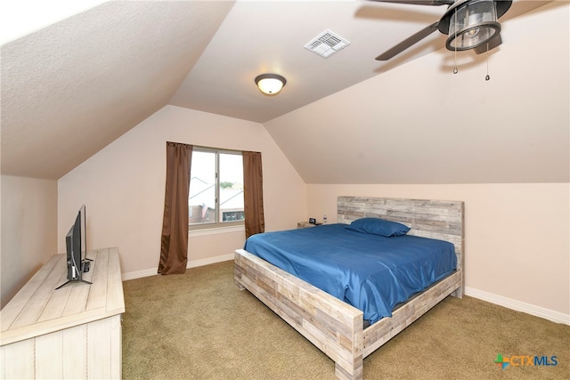 bedroom featuring lofted ceiling, a textured ceiling, carpet flooring, and ceiling fan