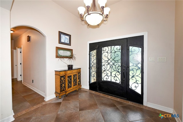 foyer entrance with an inviting chandelier and lofted ceiling