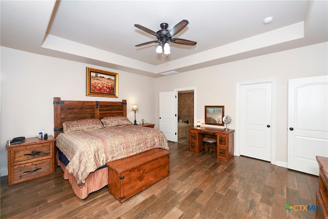 bedroom with dark wood-type flooring, ceiling fan, and a tray ceiling