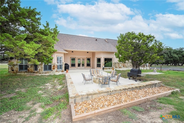 back of house featuring a patio area, a yard, and an outdoor fire pit