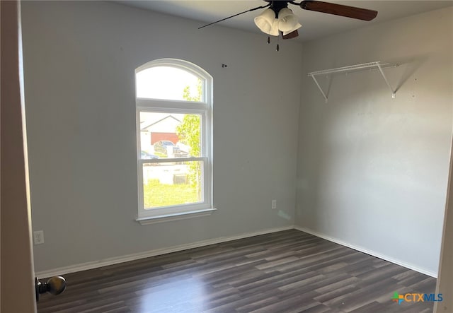 unfurnished room with dark wood-type flooring, ceiling fan, and baseboards