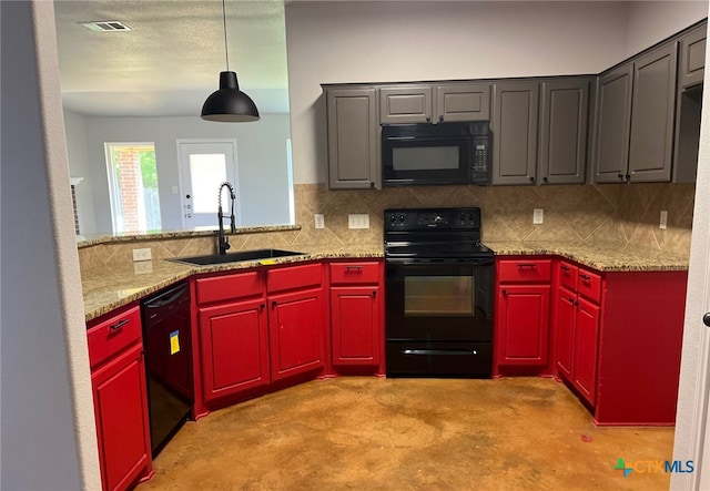 kitchen featuring concrete flooring, black appliances, a sink, red cabinetry, and decorative backsplash