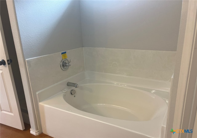 full bathroom with a bath and a textured wall