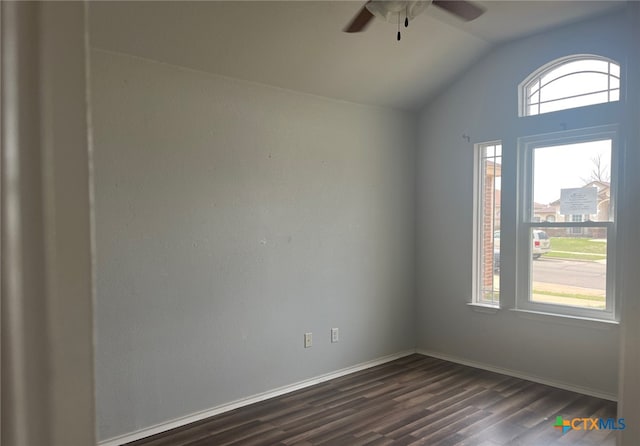 spare room with dark wood-style floors, a healthy amount of sunlight, a ceiling fan, and vaulted ceiling
