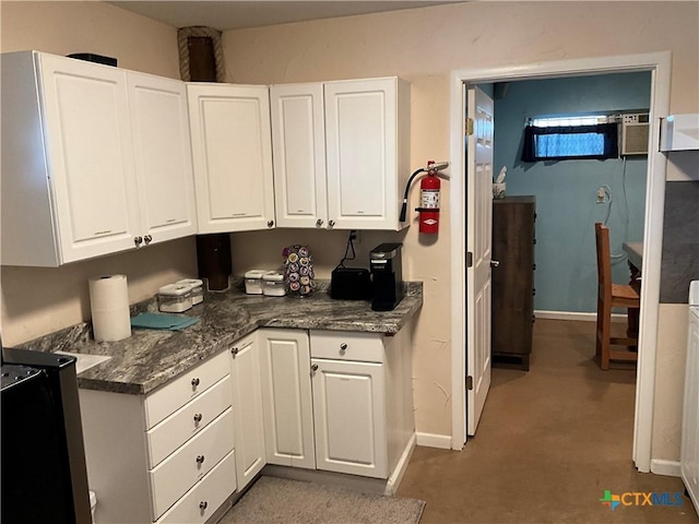 kitchen with white cabinetry and dark stone counters