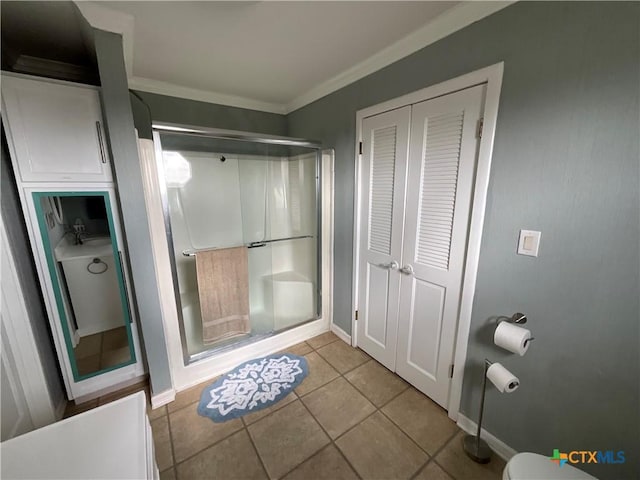 bathroom featuring a shower with door, ornamental molding, tile patterned flooring, and toilet