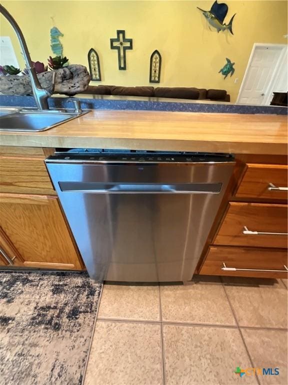 kitchen with sink, dishwasher, and light tile patterned flooring