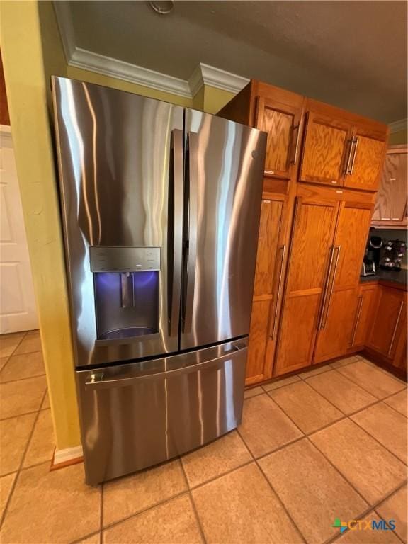 kitchen with stainless steel fridge with ice dispenser, light tile patterned floors, and ornamental molding