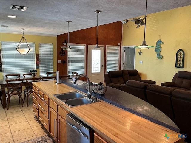 kitchen with sink, light tile patterned floors, wooden counters, dishwasher, and hanging light fixtures