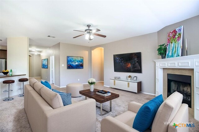 823 Kachina Loop, Harker Heights, TX 76548 - living room with light colored carpet, arched walkways, a ceiling fan, a fireplace, and baseboards