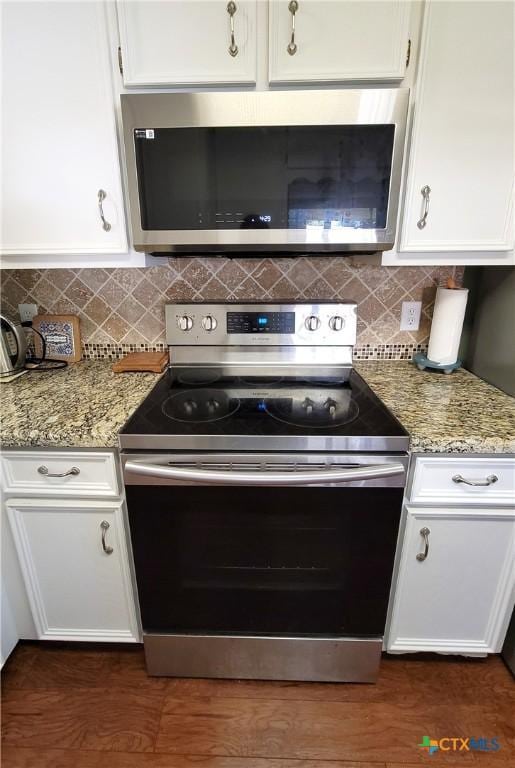 kitchen featuring decorative backsplash, stainless steel appliances, white cabinetry, and light stone counters