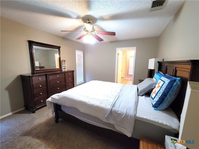 bedroom with a textured ceiling, ceiling fan, light colored carpet, and ensuite bathroom