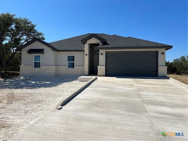 102 A Coleman, Blanco, TX 78606 - view of front of home featuring a garage, stone siding, driveway, and a shingled roof