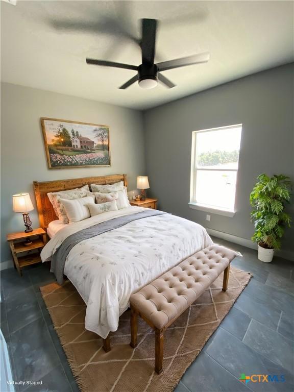 bedroom with a ceiling fan and baseboards