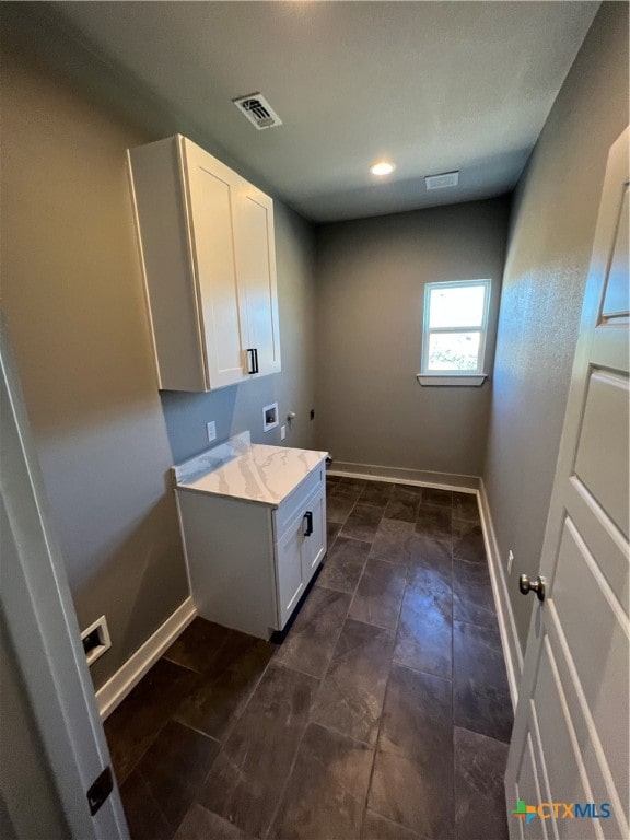 laundry room with hookup for an electric dryer, hookup for a washing machine, and cabinets