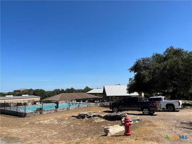 view of yard featuring fence and a community pool