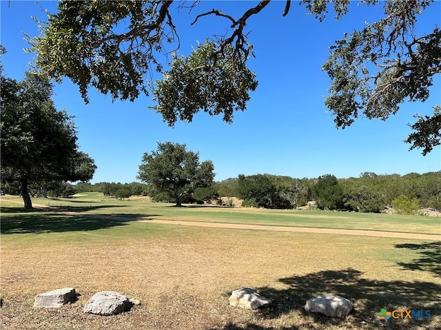 view of community with golf course view and a yard