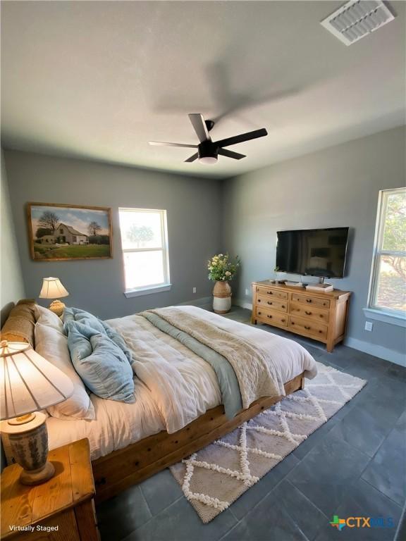 bedroom with visible vents, ceiling fan, baseboards, and multiple windows