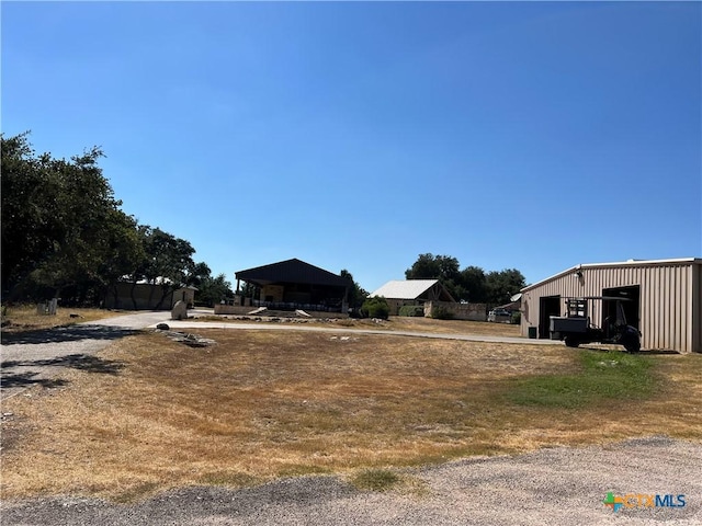 view of yard with a detached garage, a pole building, and an outdoor structure