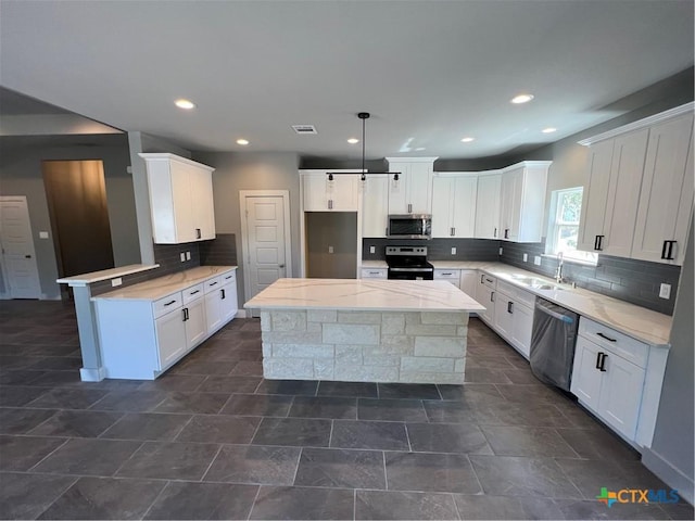 102 A Coleman, Blanco, TX 78606 - kitchen with appliances with stainless steel finishes, backsplash, recessed lighting, white cabinets, and a center island