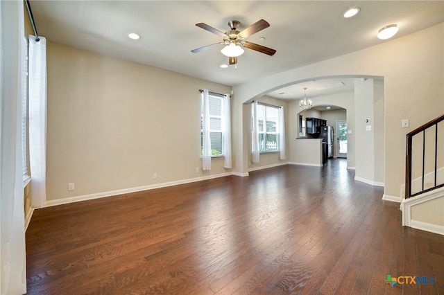 unfurnished living room featuring dark hardwood / wood-style floors and ceiling fan with notable chandelier