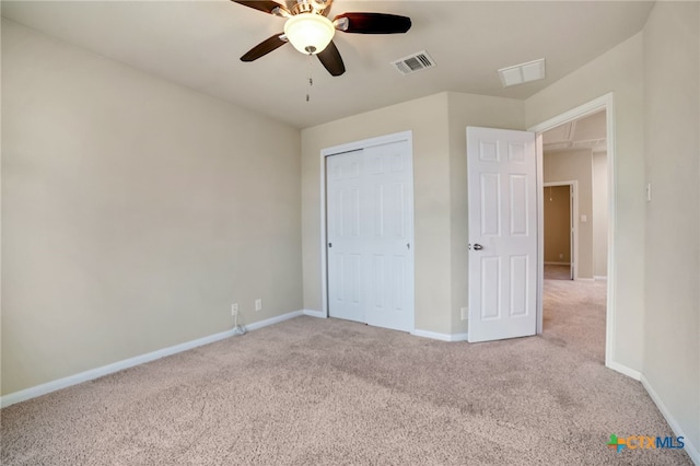 unfurnished bedroom featuring light colored carpet, ceiling fan, and a closet