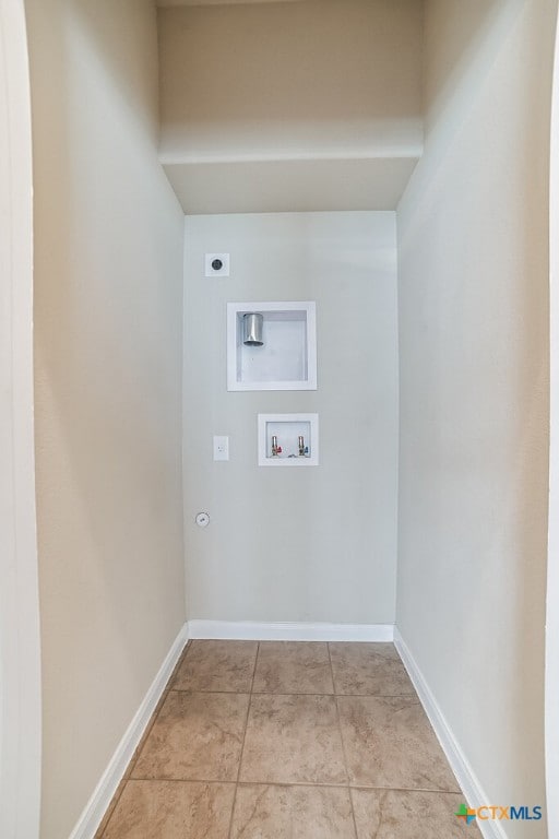 washroom with hookup for an electric dryer, gas dryer hookup, washer hookup, and light tile patterned flooring