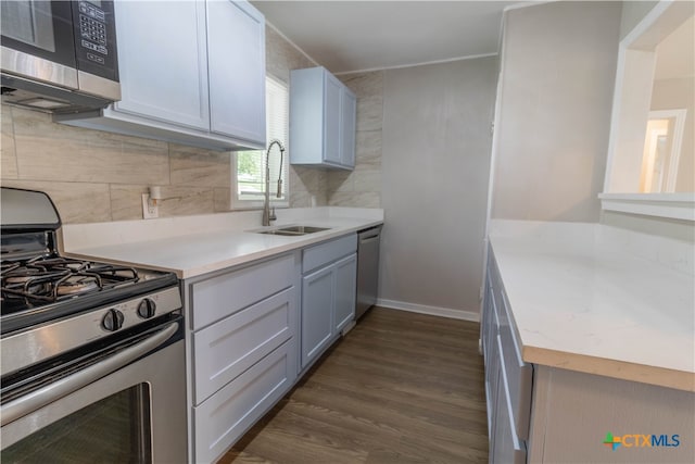 kitchen with dark hardwood / wood-style flooring, stainless steel appliances, tasteful backsplash, and sink