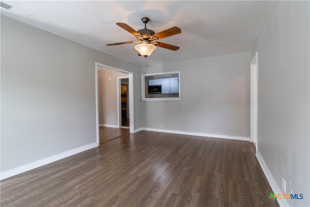 empty room featuring ceiling fan and dark wood-type flooring