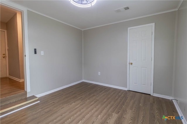 unfurnished room featuring crown molding and hardwood / wood-style flooring