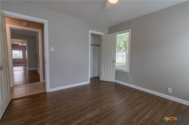 unfurnished bedroom featuring dark hardwood / wood-style flooring, a closet, and ceiling fan