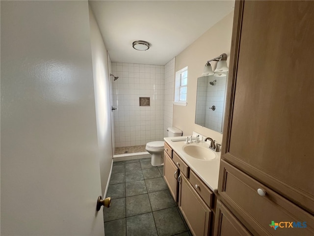 bathroom featuring toilet, tile patterned flooring, vanity, and a tile shower