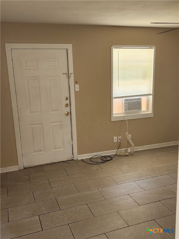 entryway featuring cooling unit, baseboards, and wood finished floors