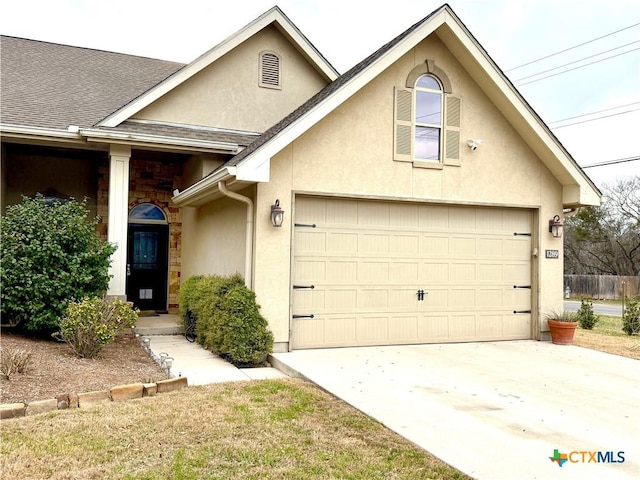 view of front of property with a garage, concrete driveway, roof with shingles, and stucco siding