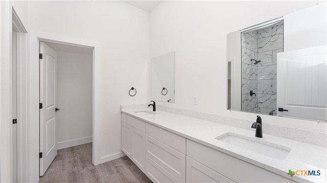 bathroom featuring a tile shower, vanity, and hardwood / wood-style floors