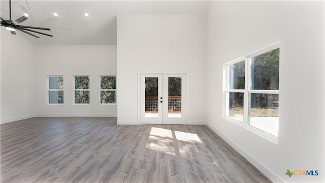 unfurnished living room featuring ceiling fan, light hardwood / wood-style flooring, french doors, and plenty of natural light