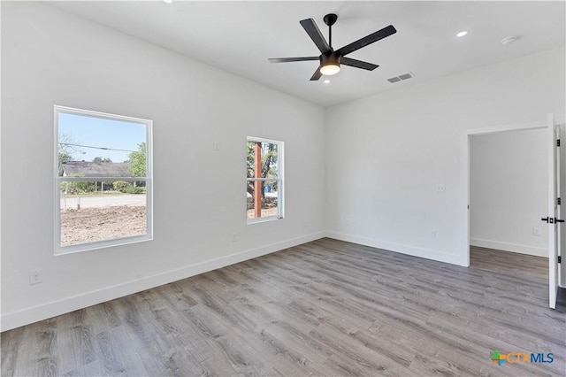 spare room with ceiling fan and light wood-type flooring