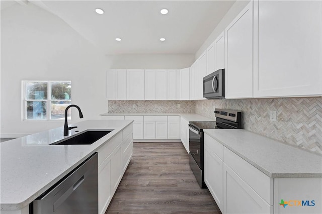 kitchen featuring sink, white cabinets, a kitchen island with sink, and appliances with stainless steel finishes