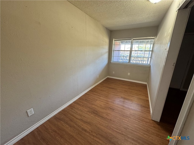 unfurnished room featuring a textured ceiling and hardwood / wood-style flooring