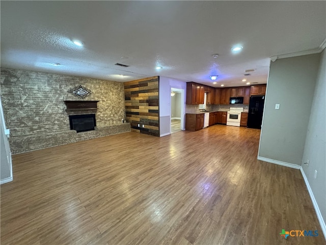 unfurnished living room with a textured ceiling, dark hardwood / wood-style floors, and ornamental molding