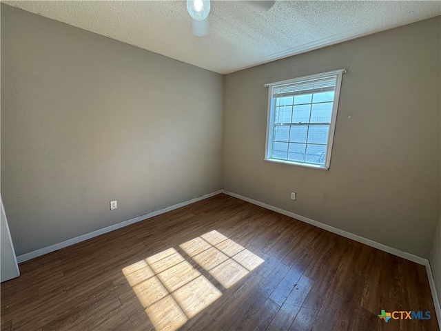 unfurnished room featuring a textured ceiling and dark wood-type flooring