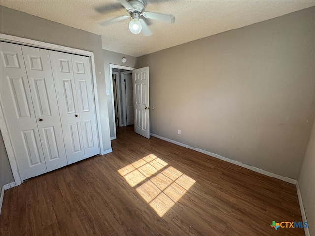 unfurnished bedroom featuring a textured ceiling, dark hardwood / wood-style flooring, a closet, and ceiling fan