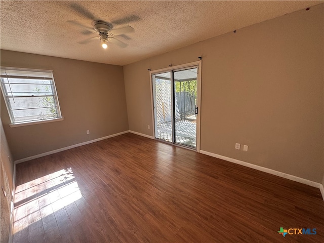 empty room featuring a textured ceiling, dark hardwood / wood-style flooring, and ceiling fan