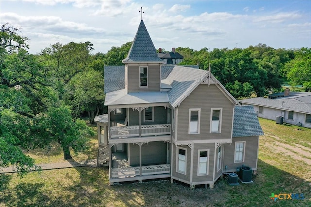 back of house featuring a lawn, central AC unit, and a balcony
