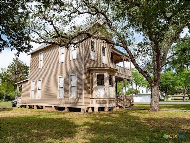 view of property exterior featuring a lawn and a balcony
