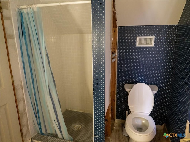bathroom with toilet and a stall shower
