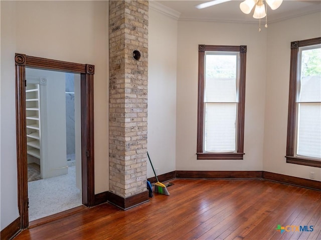 unfurnished room featuring hardwood / wood-style floors, ornamental molding, baseboards, and ceiling fan