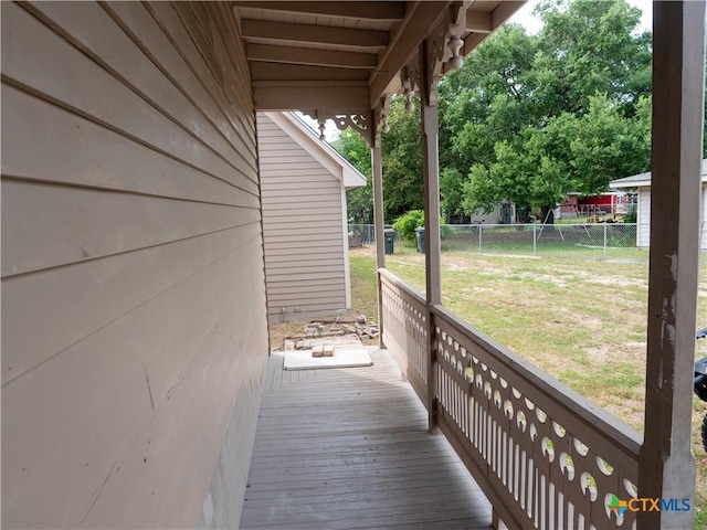 wooden deck with a lawn and fence