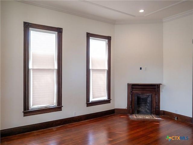 unfurnished living room featuring baseboards, ornamental molding, wood finished floors, and a fireplace